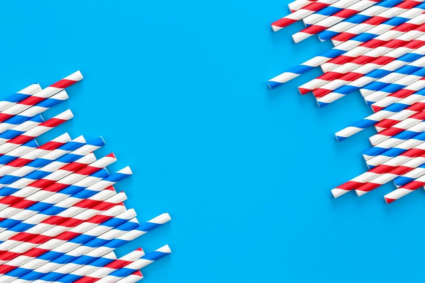 Strohhalme für eine Party auf blauem Hintergrund mit Platz für Text